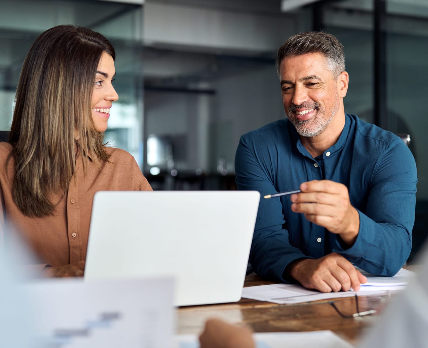 man-woman-desk-laptop-pen