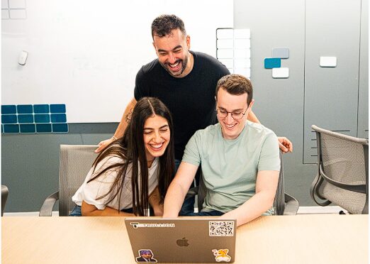 a paper with blue and gray charts and graphs sits on a table. A pen, magnifying glass and calculator lay on top of it.